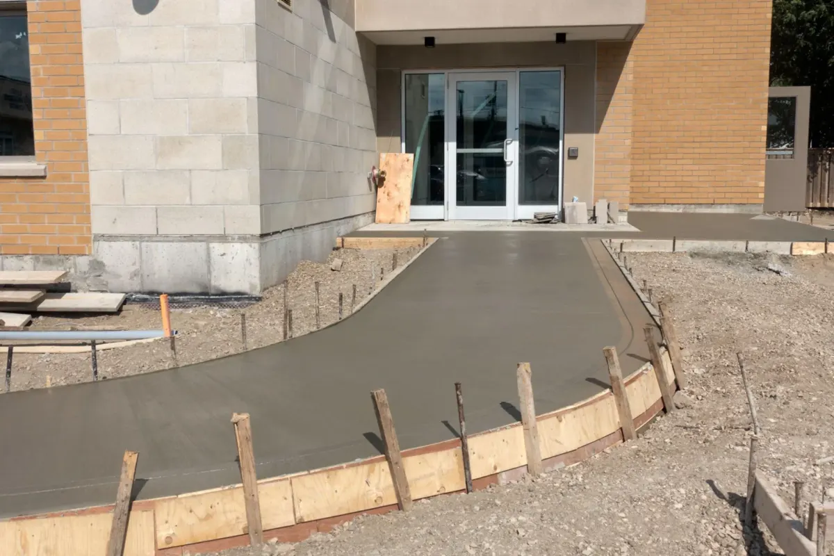 crew forming a curved concrete walkway with wood forms in Westgate