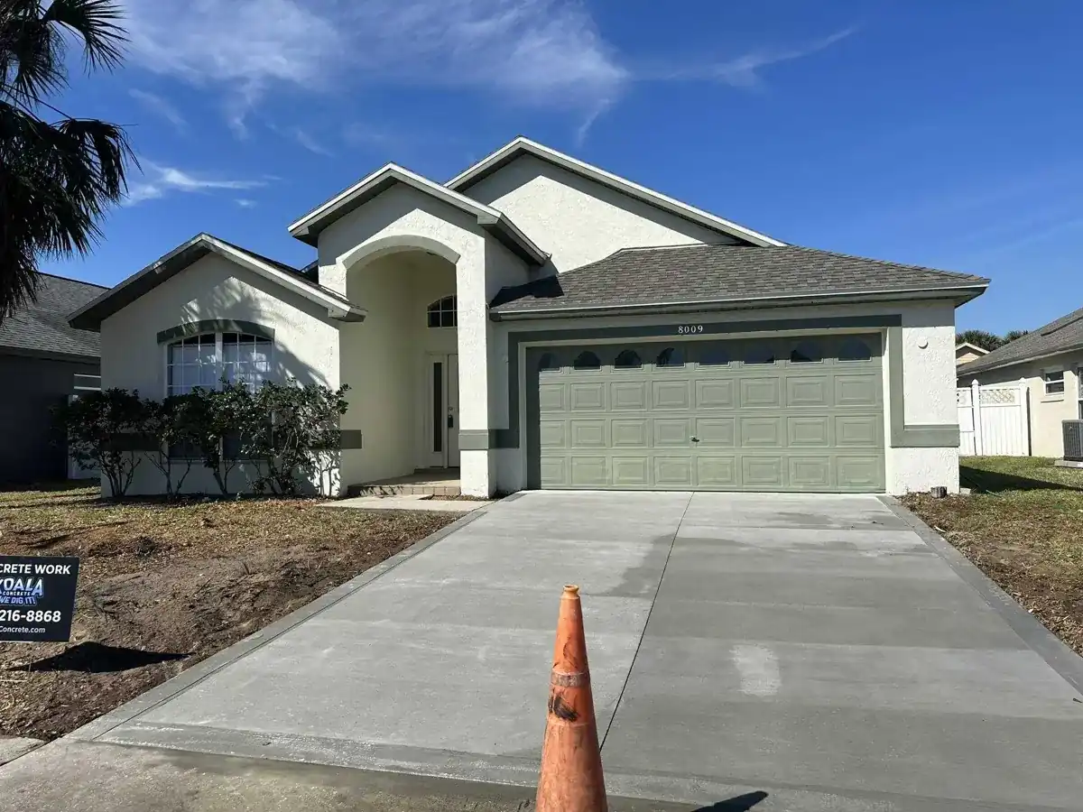 fresh broom finish concrete driveway leading to a stucco home garage in Royal Palm Beach