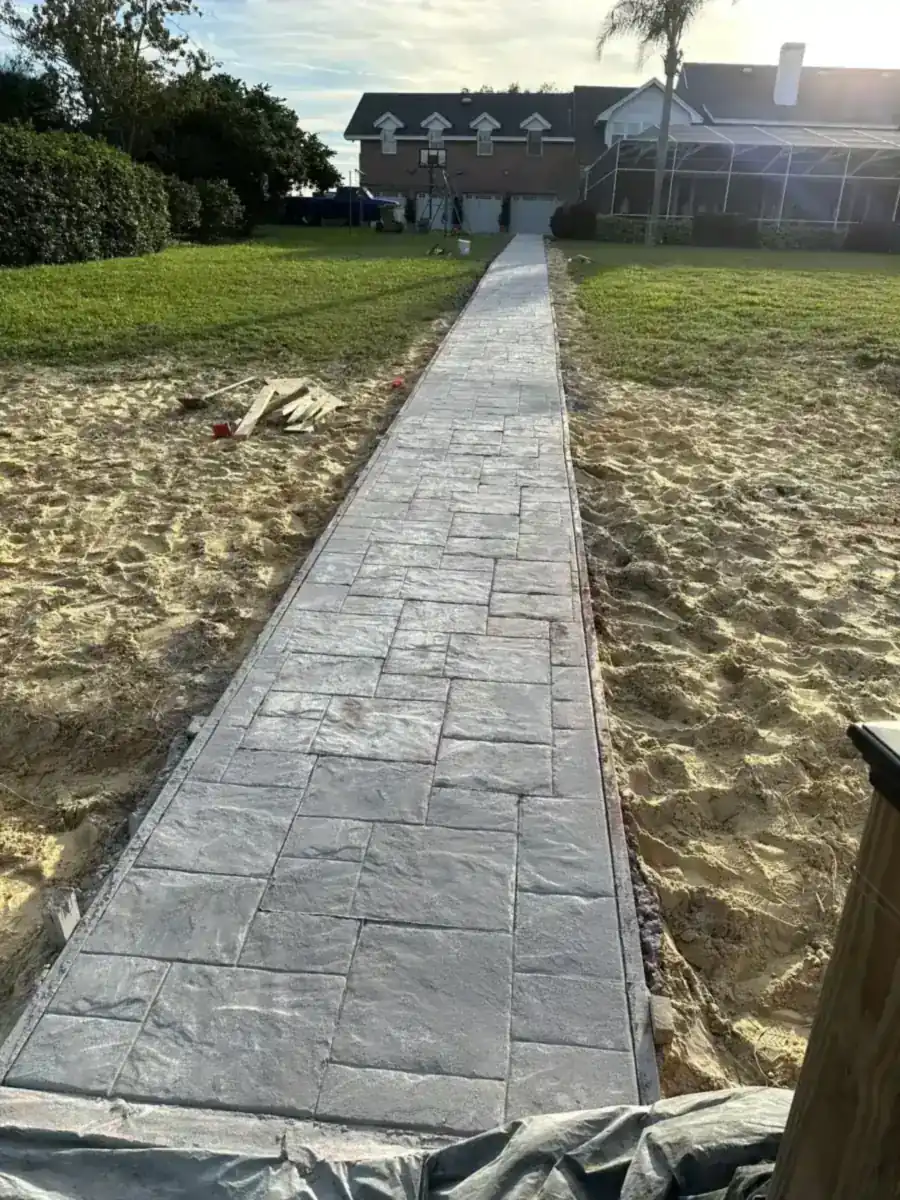 long stamped concrete walkway across a sandy yard to a house in Westlake