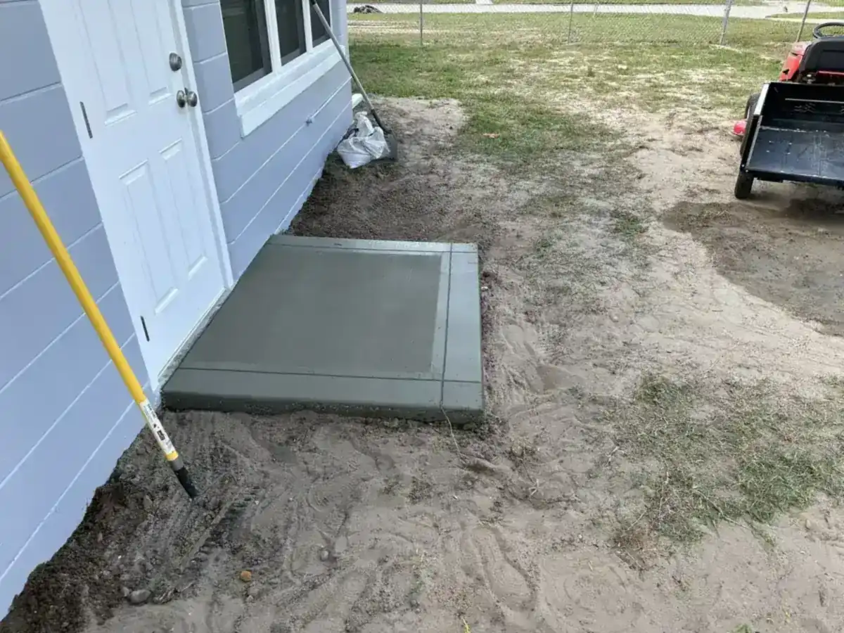 small new concrete pad poured at a side door of a house in Wellington