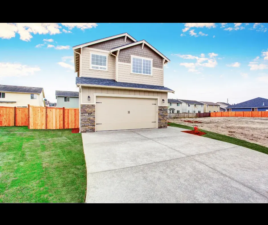 wide new concrete driveway at a two story home with a wood privacy fence in Royal Palm Beach